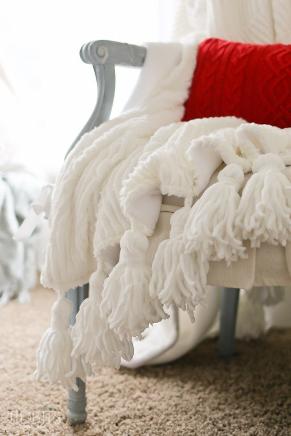 Tassel Throw Blanket DIY - Instructions for how to make your own tassels from yarn and how to sew them into fabric to make a one of a kind throw blanket.