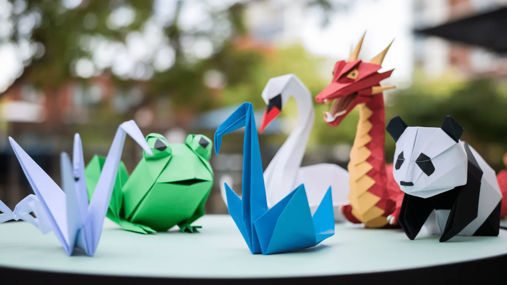 animals made from folded paper origami panda, frog, swan and bird with small dot marker eyes
