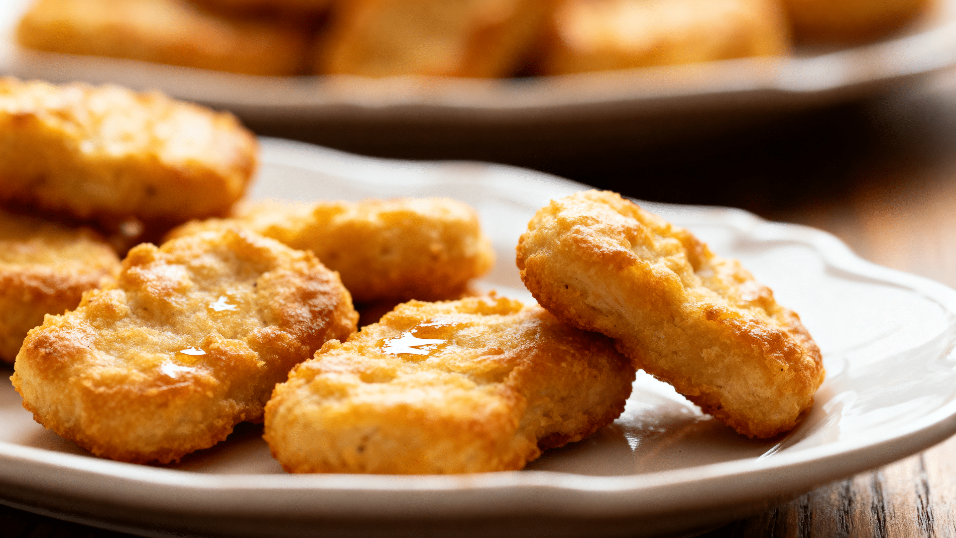 baked chicken nuggets arranged in rows with dipping sauces in small bowls on the side