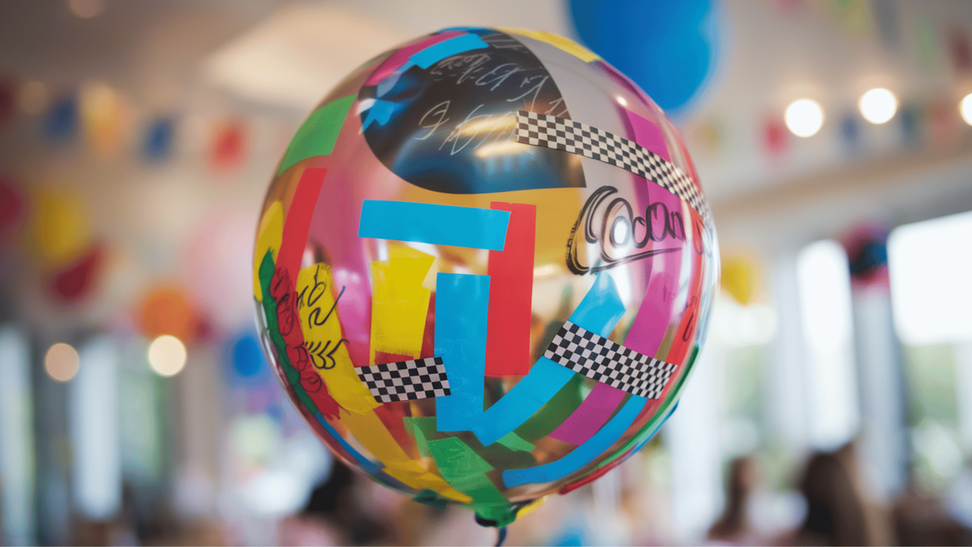 balloon decorated with colorful tape strips, permanent marker designs, floating in mid-air