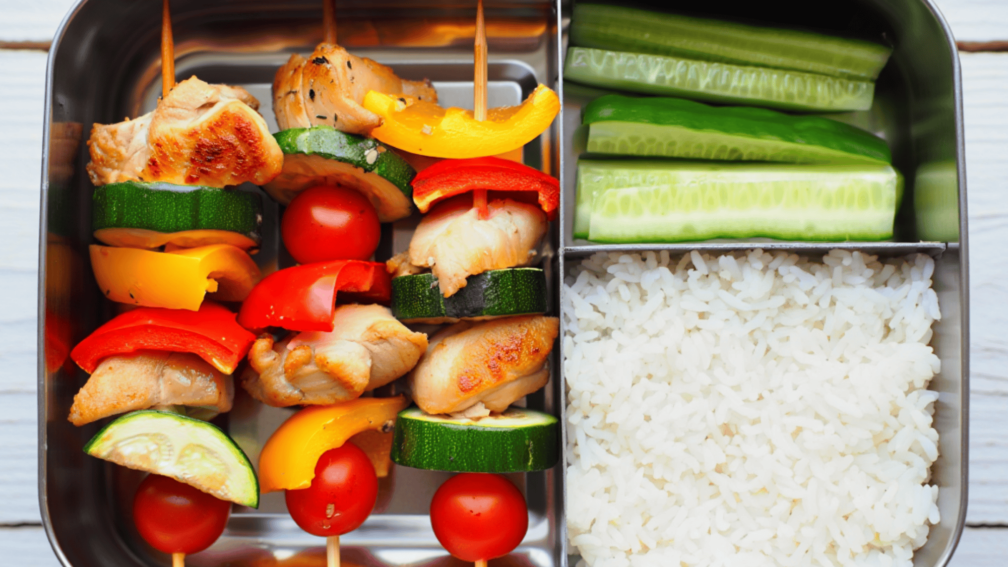 chicken and veggie skewers in a three department lunch
