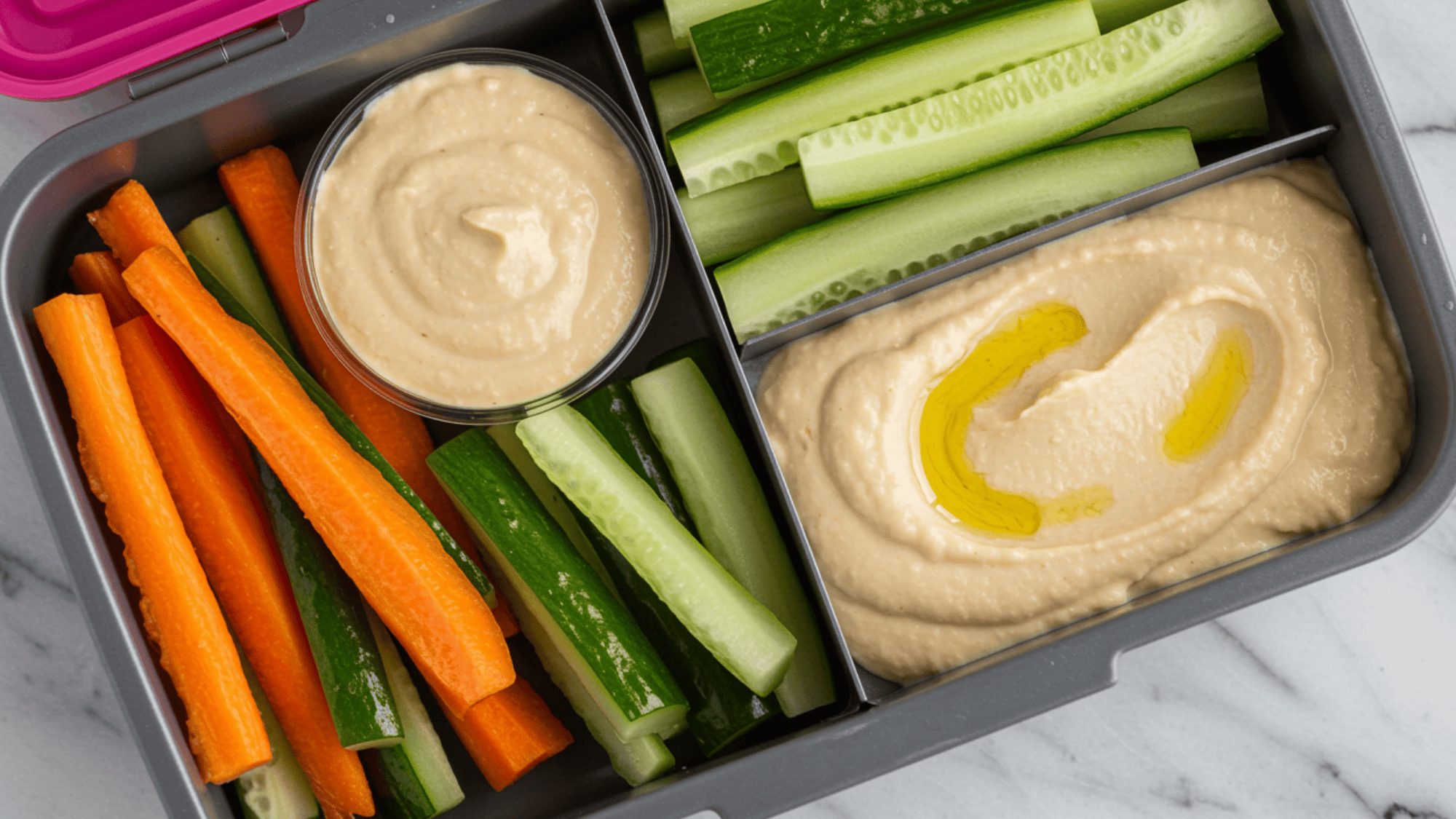 crunchy veggie sticks and smooth hummus in a lunchbox, colorful sliced carrots and cucumbers, sesame garnish
