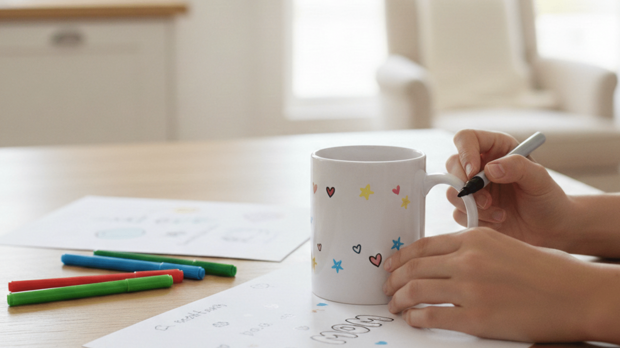 decorating a personalized mug with colorful markers on a table