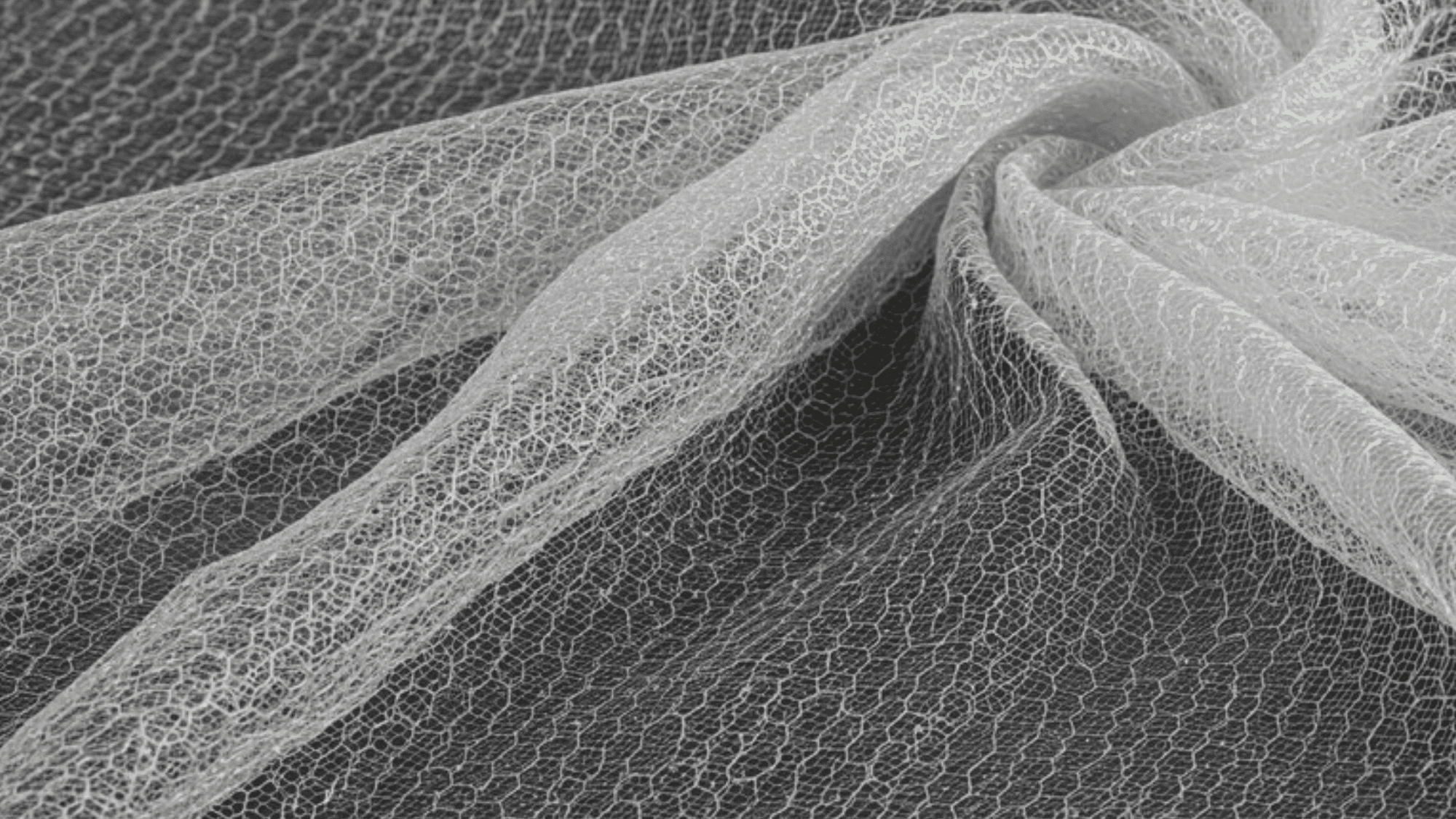 delicate tulle fabric, pale blush layers, soft translucent folds, subtle sheen