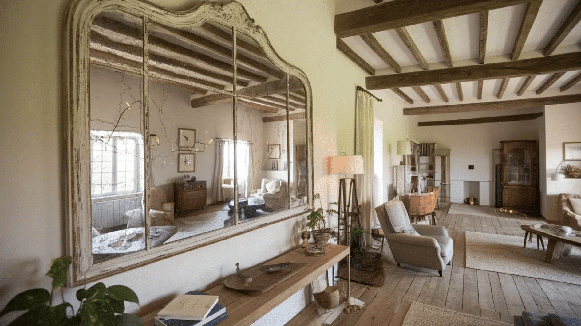 living room with a vintage mirror, exposed wooden beams, and cozy furniture, creating a warm, inviting atmosphere