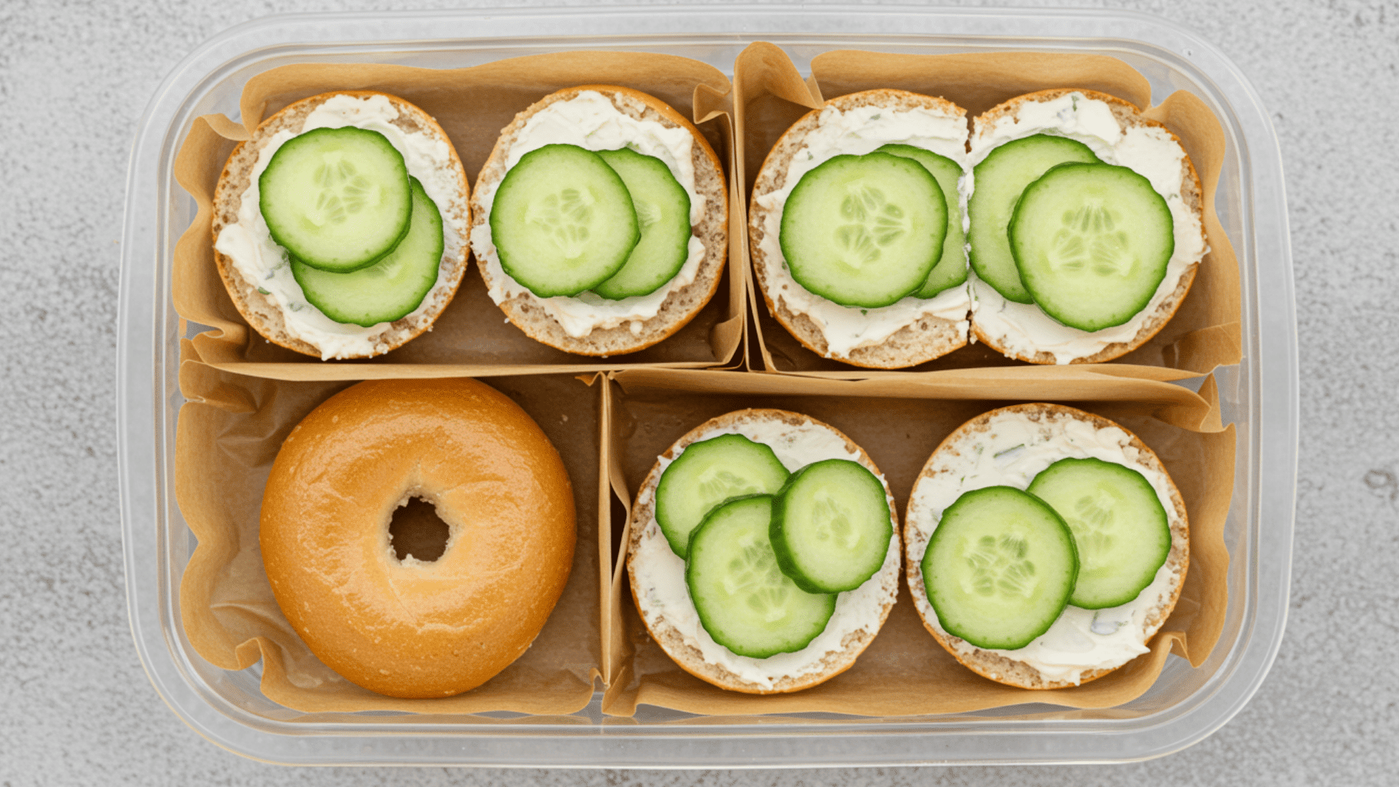 mini bagels topped with cream cheese and thin cucumber slices