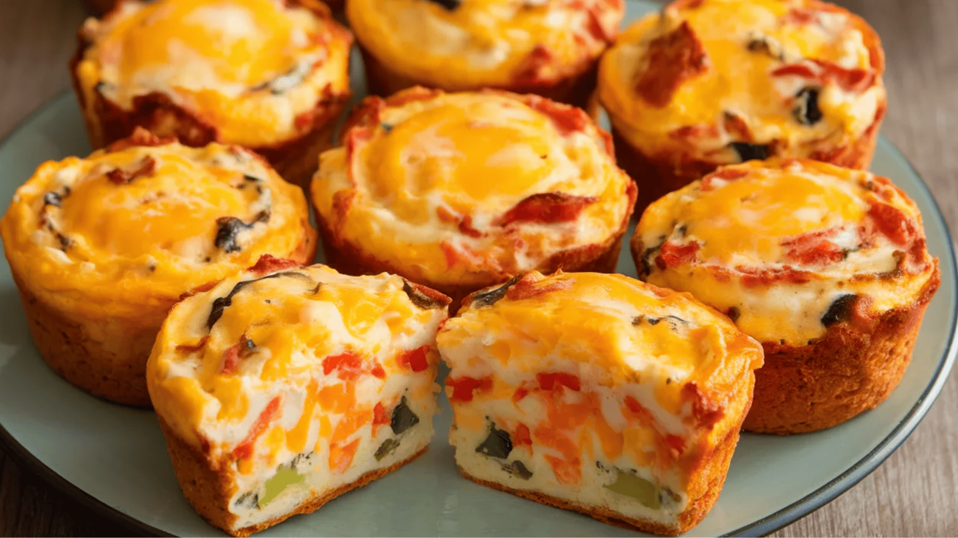 mini egg muffins with cheese, bell peppers, and spinach, with one muffin cut in half to show the filling