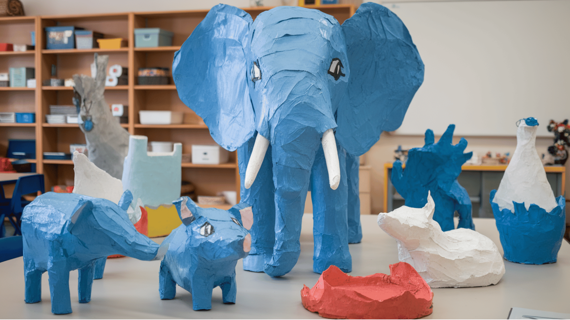 paper mache animal sculptures displayed on a classroom table during an art project.