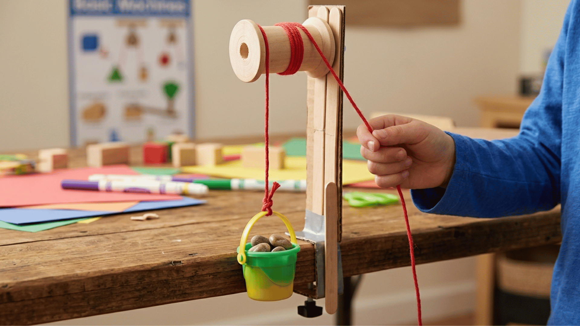 simple pulley system for kids made with string, spool, and small hanging bucket