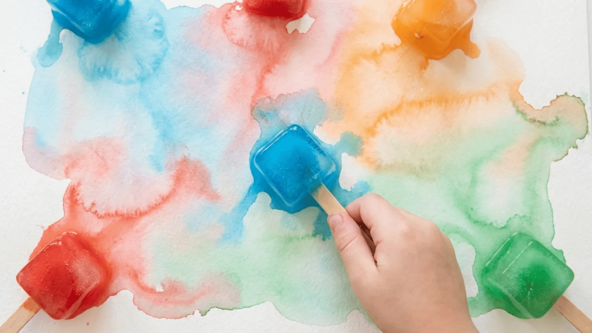 soft melted blue and red watercolor streaks on white paper made with frozen paint cubes