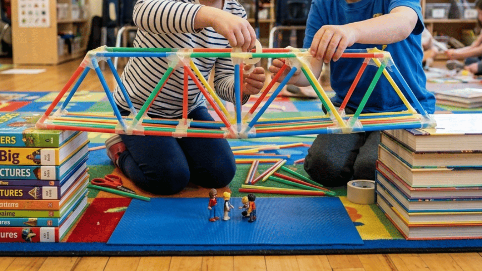 straw bridge building activity for kids with tape and books as supports