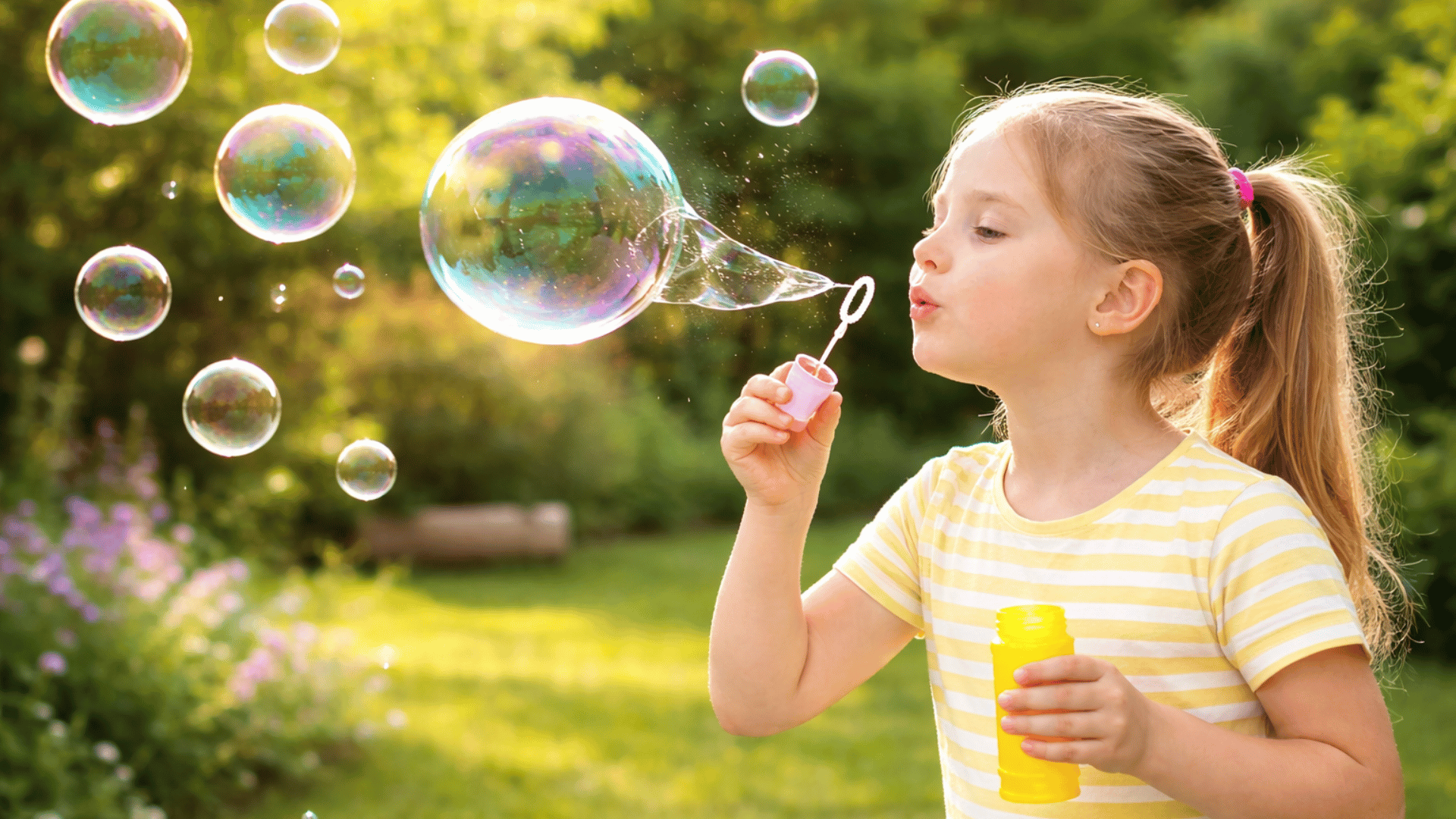 a young girl blows bubbles outside, practicing slow, controlled breathing as she enjoys the moment