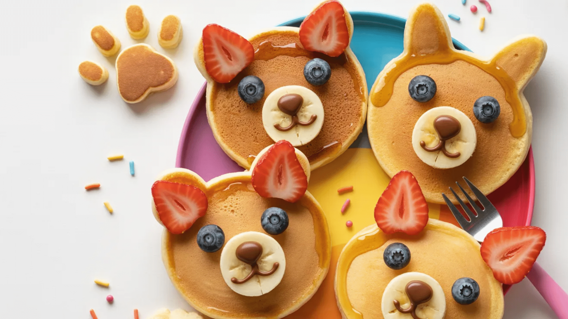 animal-shaped pancakes decorated with fruit and syrup faces