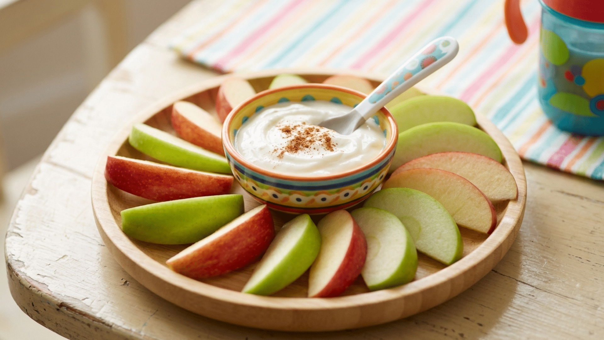 apple slices served with yogurt dip and cinnamon for a simple toddler snack