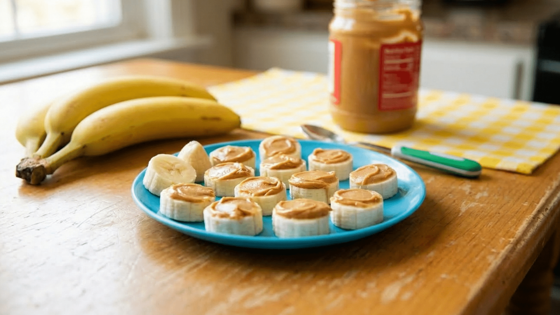 banana slices topped with peanut butter on a plate for a healthy toddler snack.