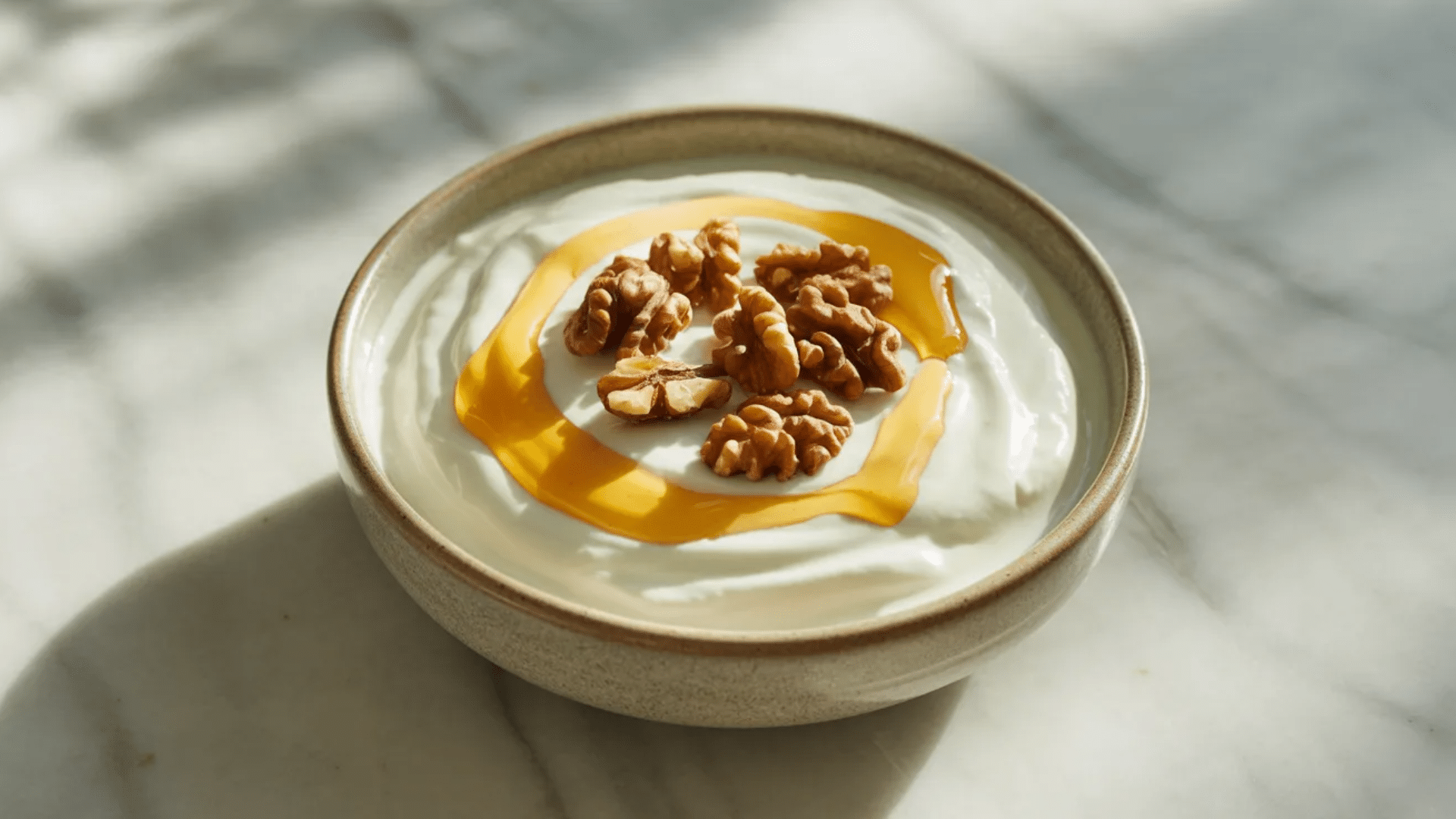 bowl of yogurt topped with honey and walnuts