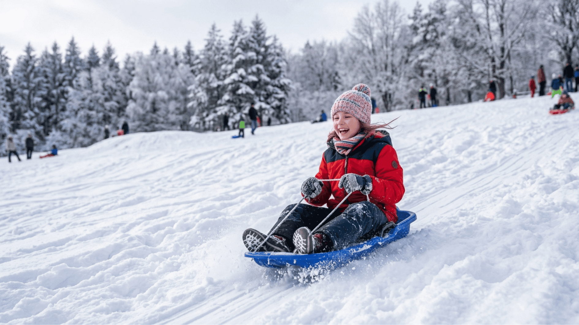 child sledding down snowy hill with smile enjoying winter fun in a park filled with snow-covered trees