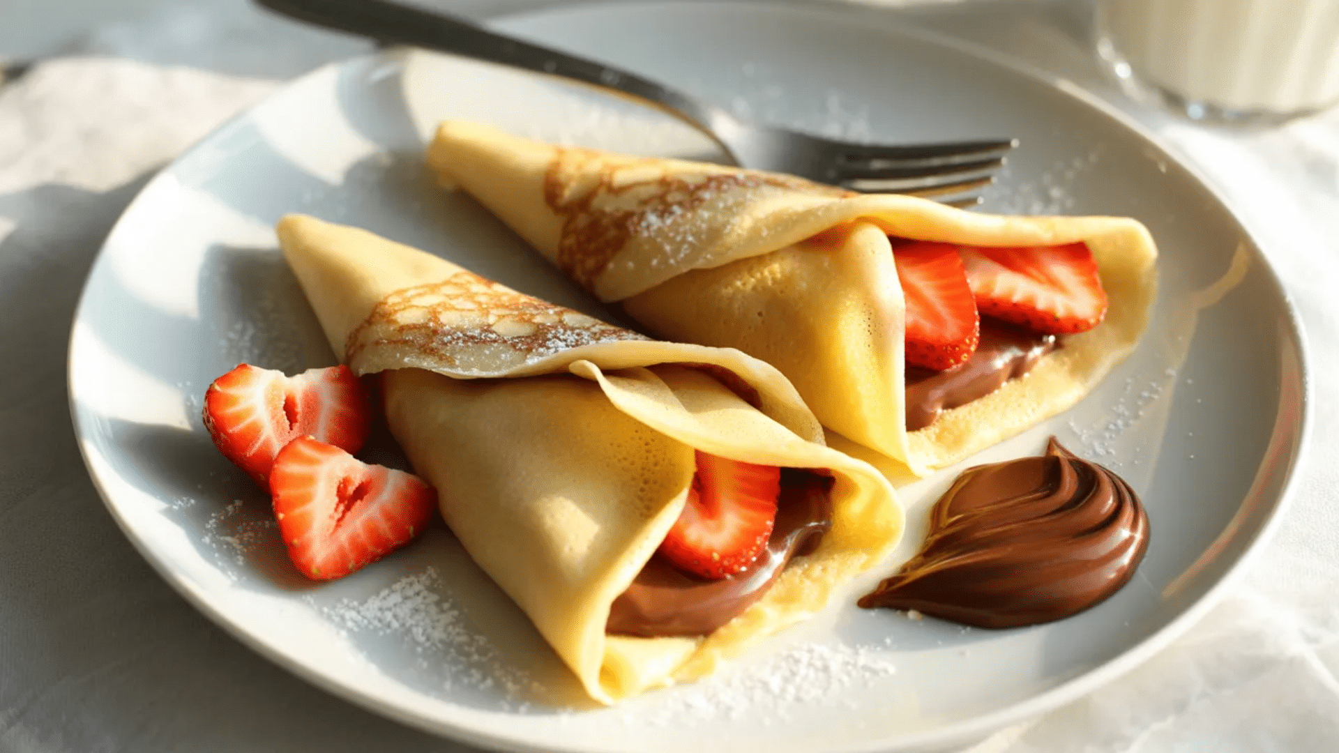 crepes filled with chocolate spread and strawberries on a plate