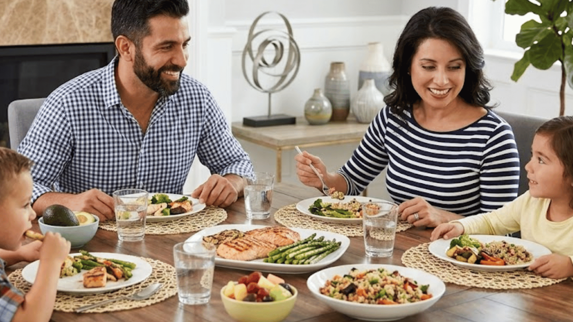 family of four enjoying a healthy dinner together at a dining table in a bright and cozy home setting