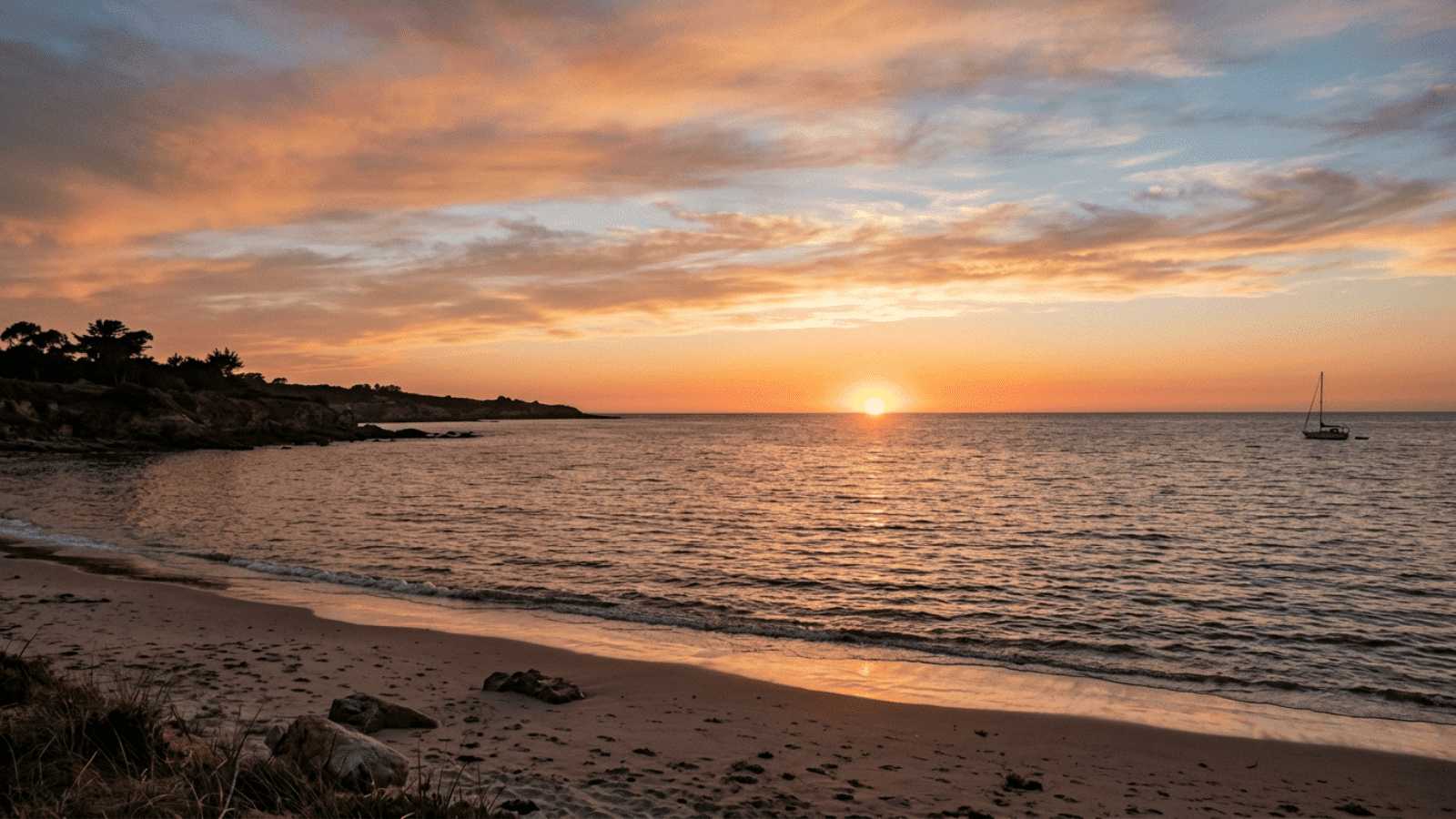 golden sunset or sunrise over a calm beach soft pink and amber sky reflected in still water