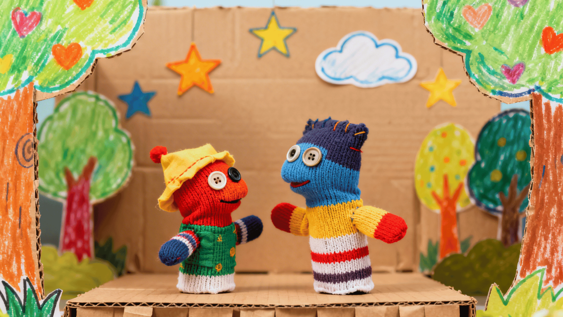 handmade puppet stage with sock puppets and a cardboard background ready for a fun storytelling show