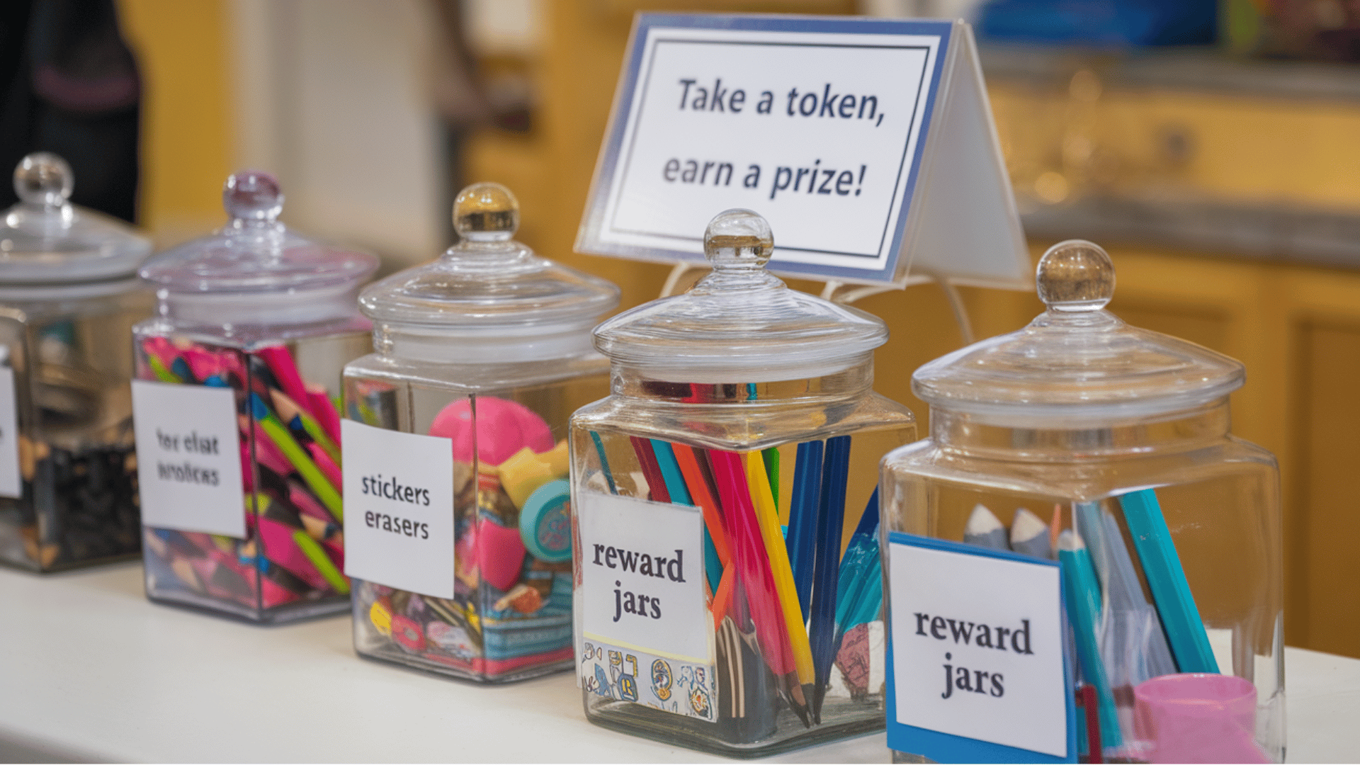 jars filled with rewards like stickers and pencils on a table with a prize sign