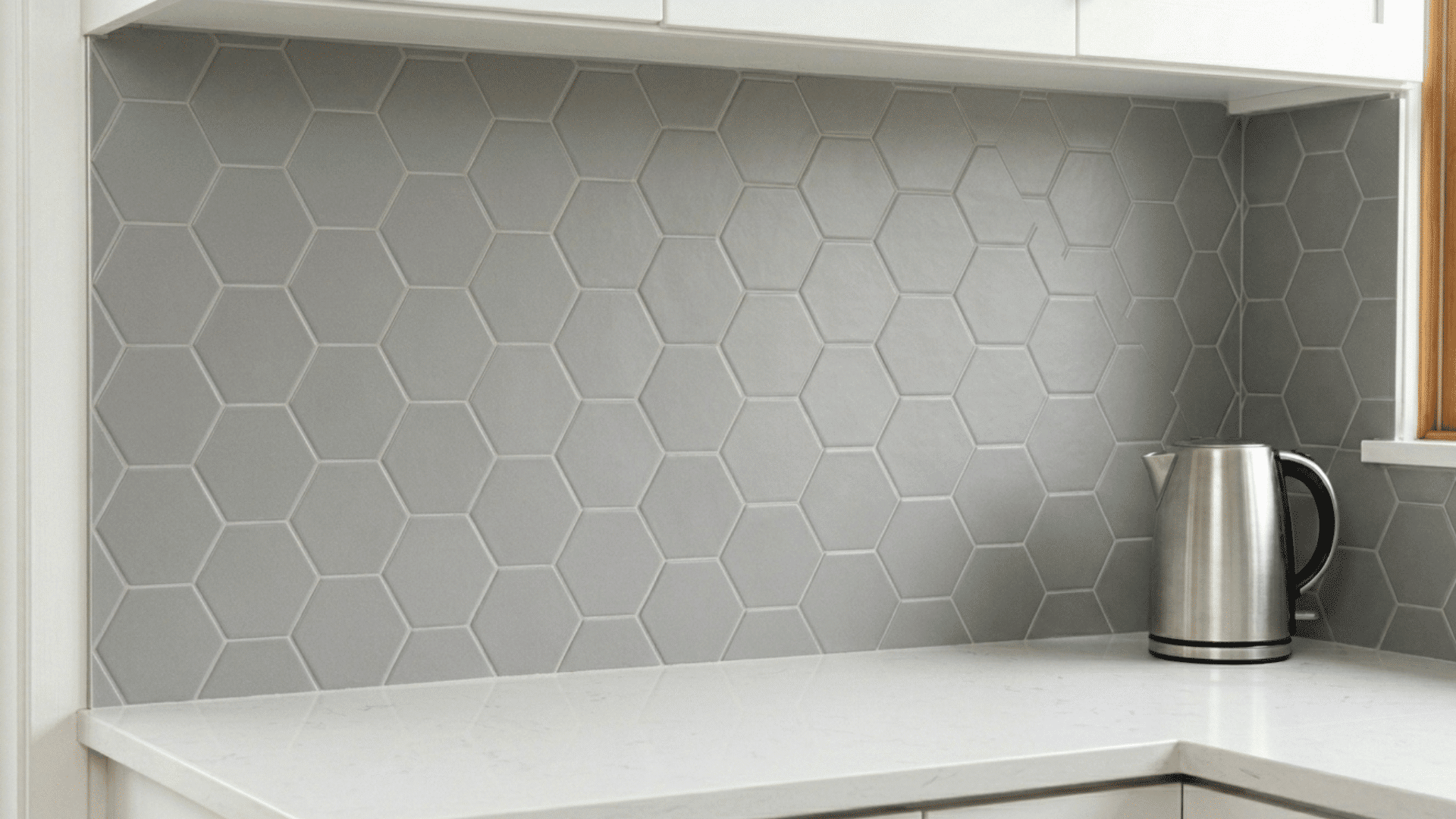modern kitchen with gray hexagon peel-and-stick backsplash and clean white countertop.