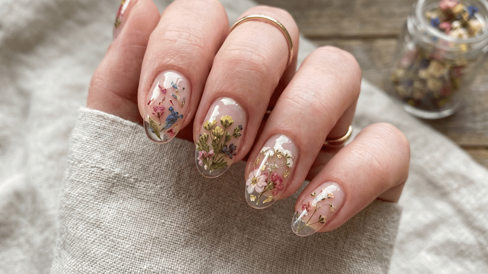 pressed flower nail design with real dried flowers on clear glossy nails