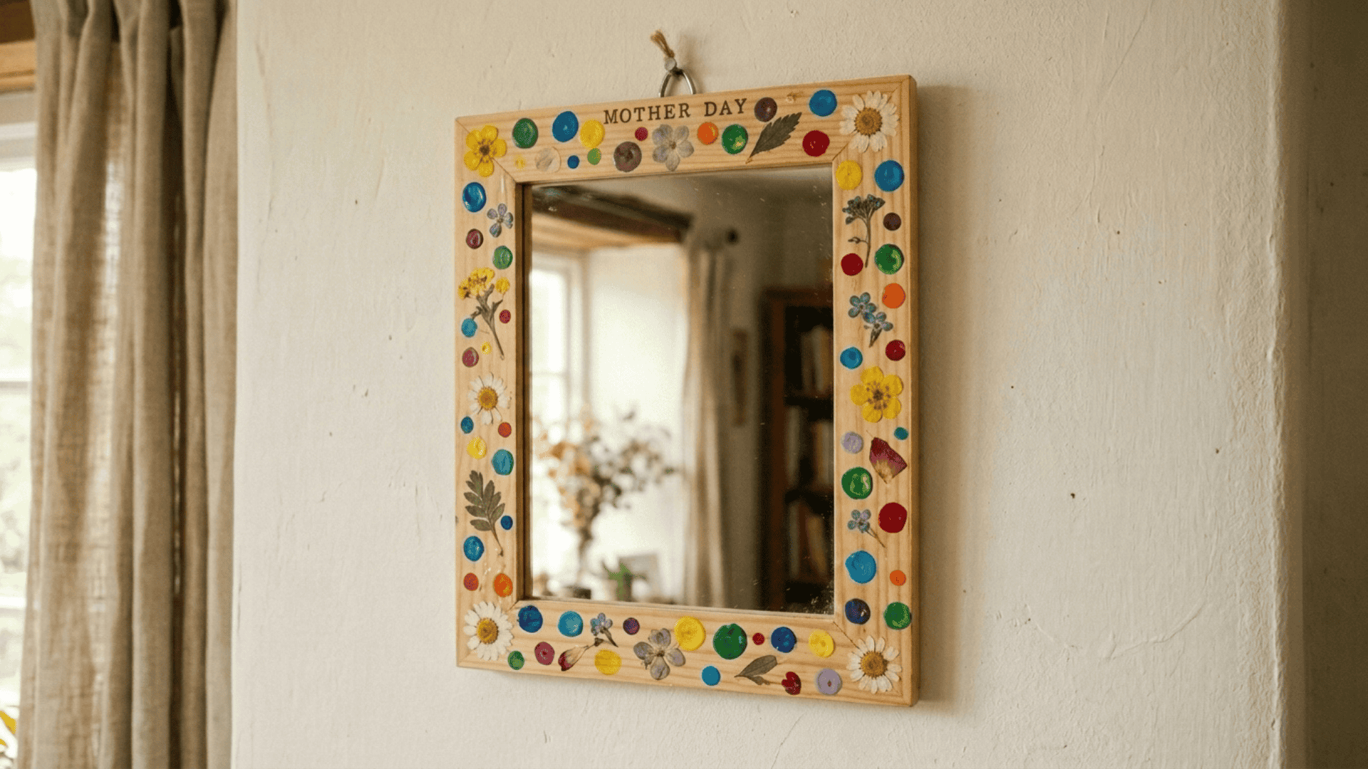 small mirror with wooden frame decorated with painted dots and pressed flowers as a handmade mothers day gift idea