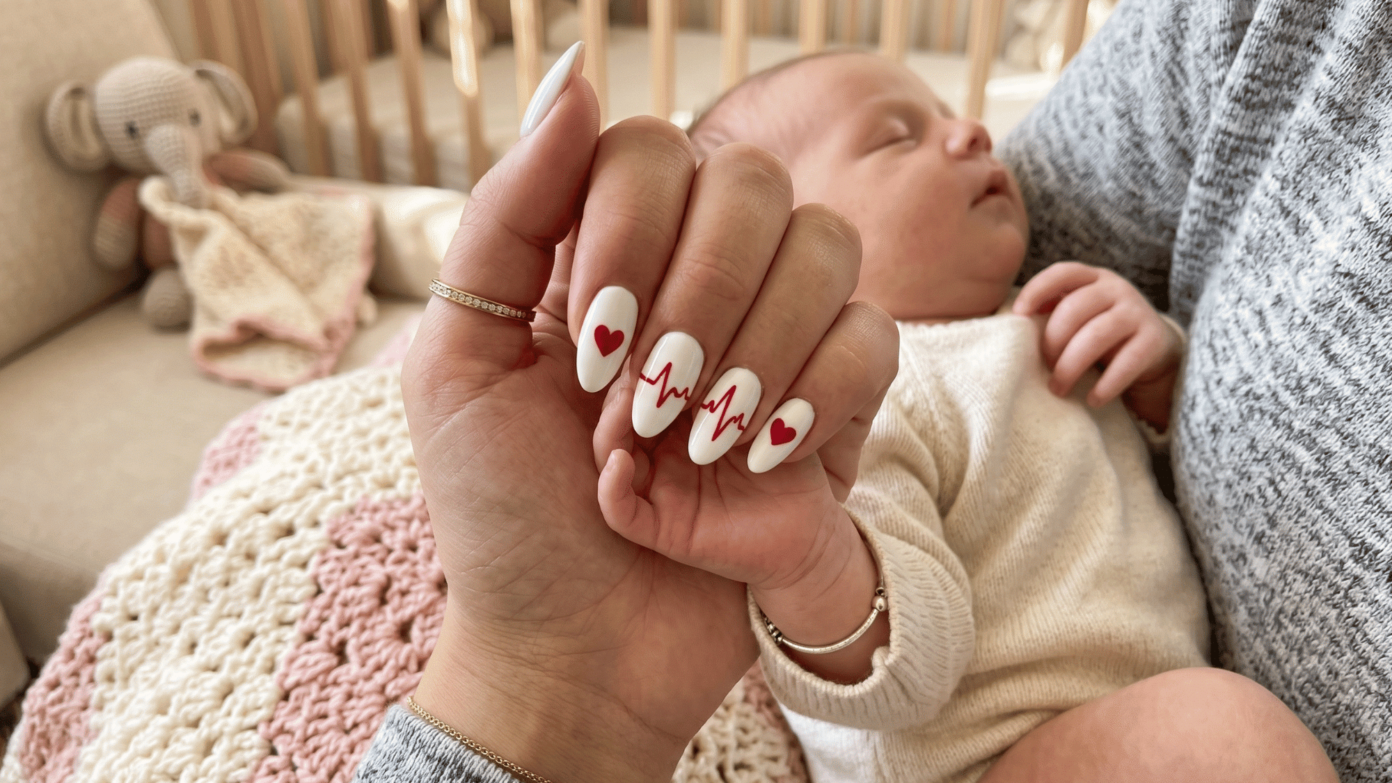 white nails with red heartbeat line design symbolizing love and motherhood