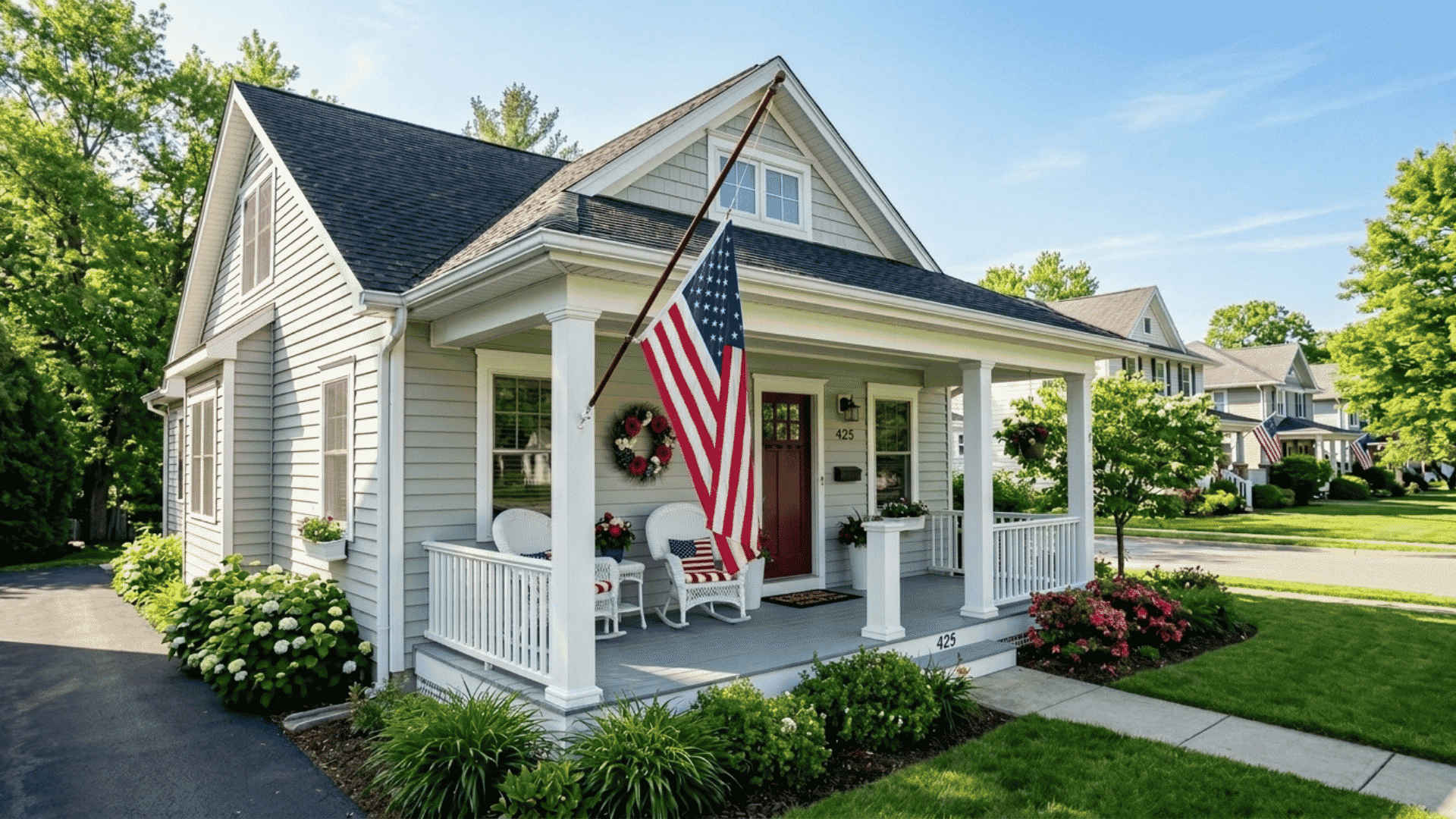 american flag displayed at half-staff on a house porch on memorial day morning