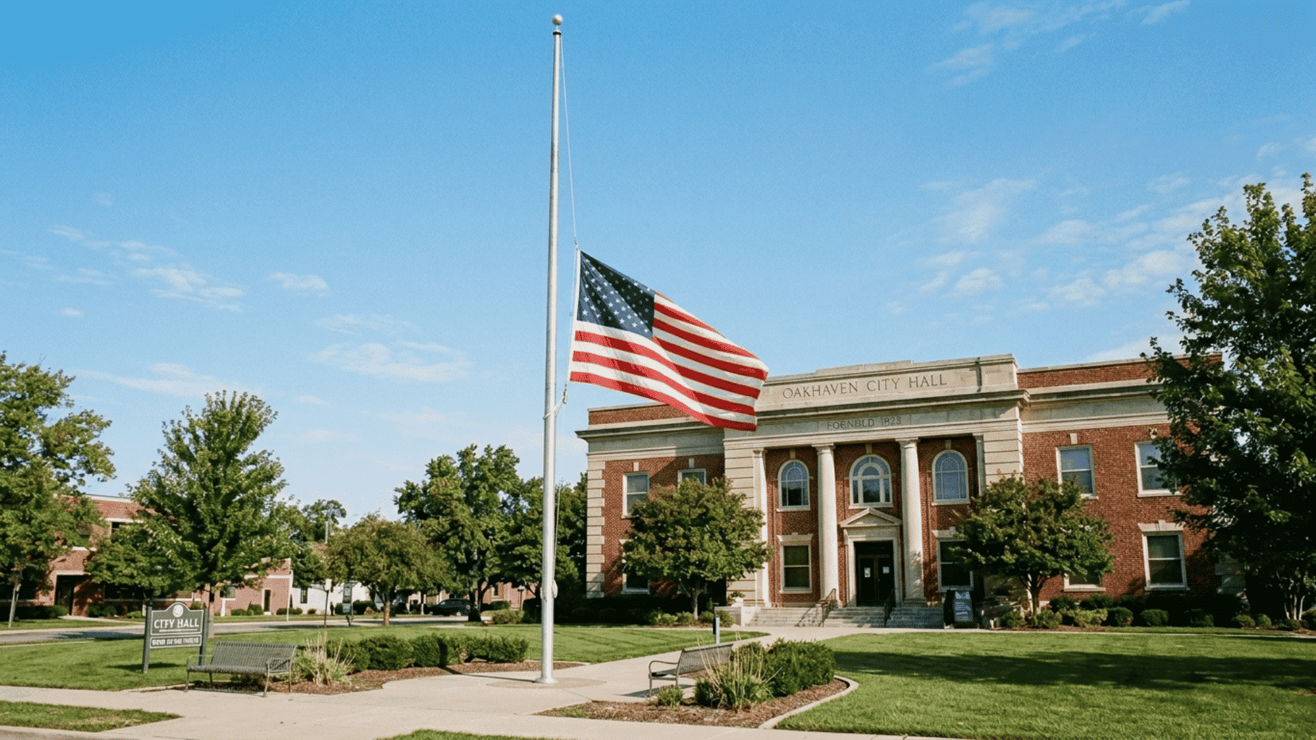 an american flag lowered to half staff on a flagpole outside a government building on memorial day