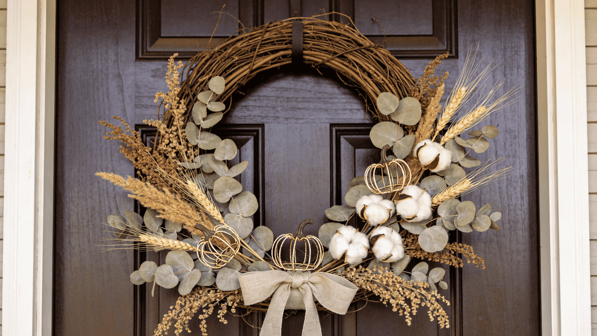 dried botanical wreath with eucalyptus wheat and cotton stems on a dark wooden front door in fall (2)