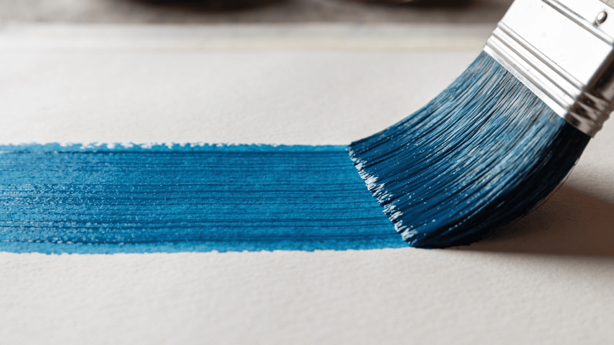 flat brush painting smooth blue watercolor stroke across textured white paper
