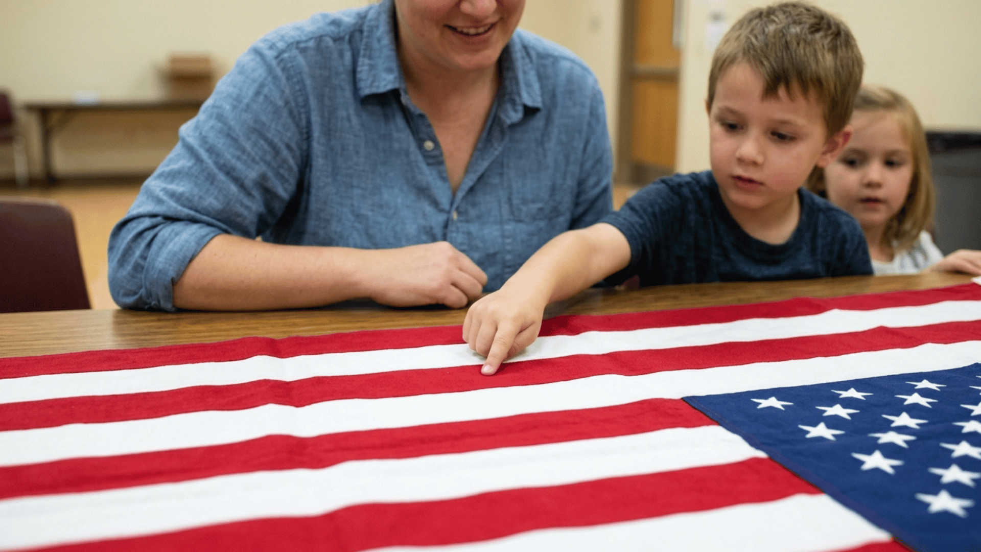 kid learning American flag stripes and stars with parent guiding on table.