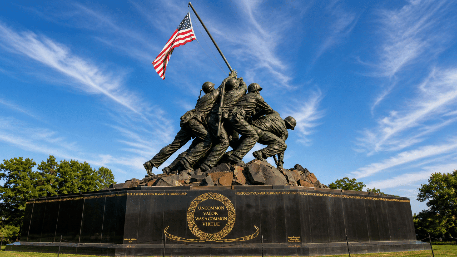 memorial statue with american flag under blue sky during memorial day remembrance event