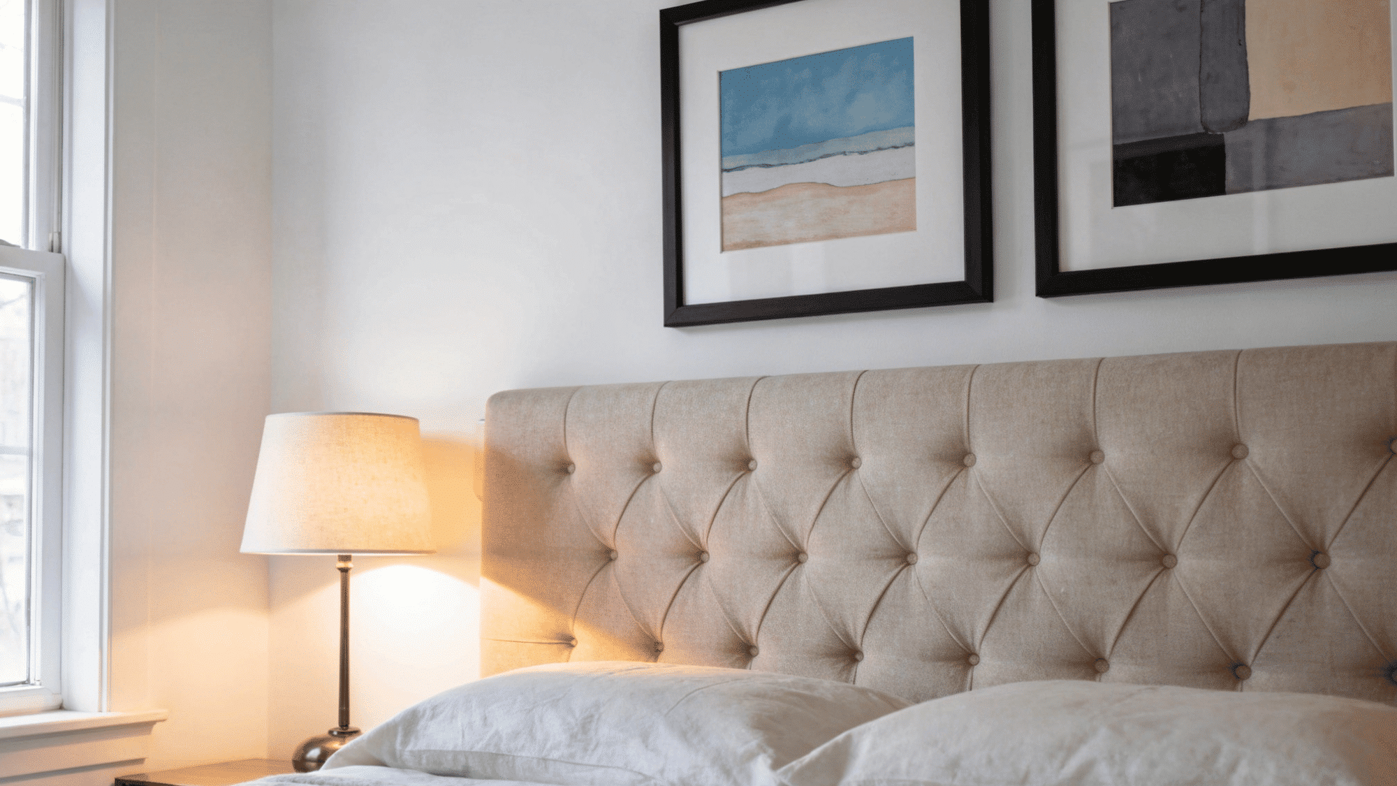 _spare bedroom gallery wall with two to three matching framed prints grouped above an upholstered headboard