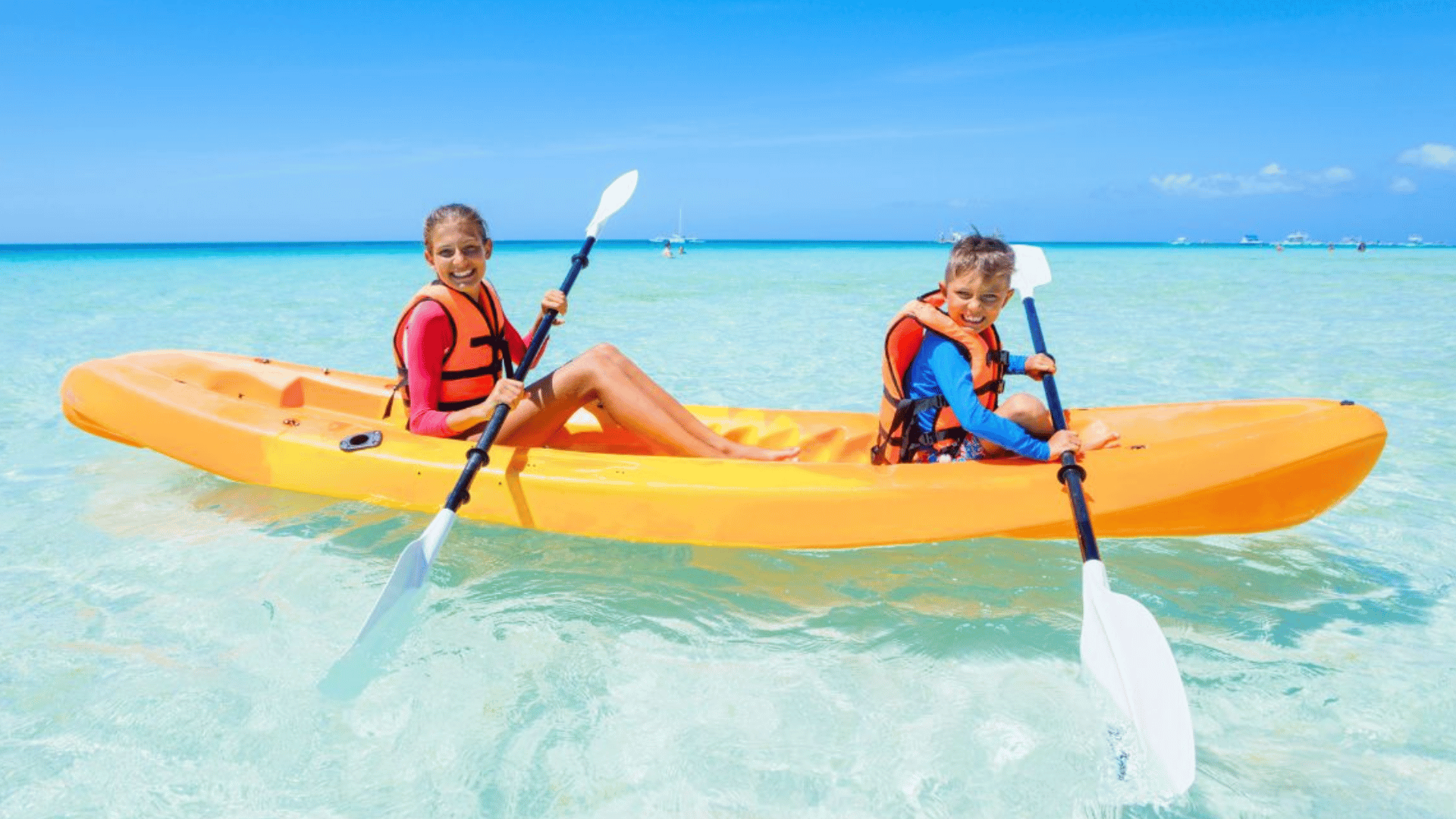 two people kayaking together on calm blue water during a relaxing memorial day outdoor adventure
