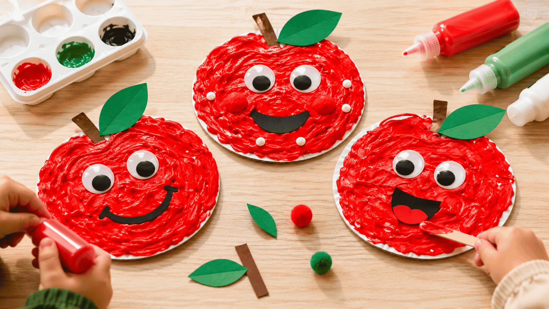 apple craft of puffy painted apple craft three different apples with facial expressions in an toddler craft setting and craft materials on side