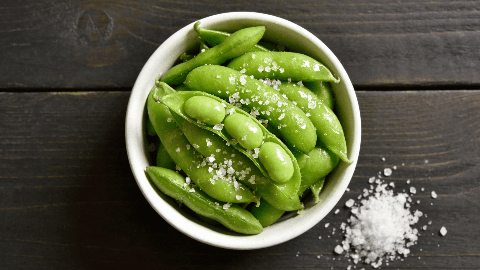bowl of steamed green edamame pods sprinkled with flaky sea salt, healthy quick snack meal ideas for kids