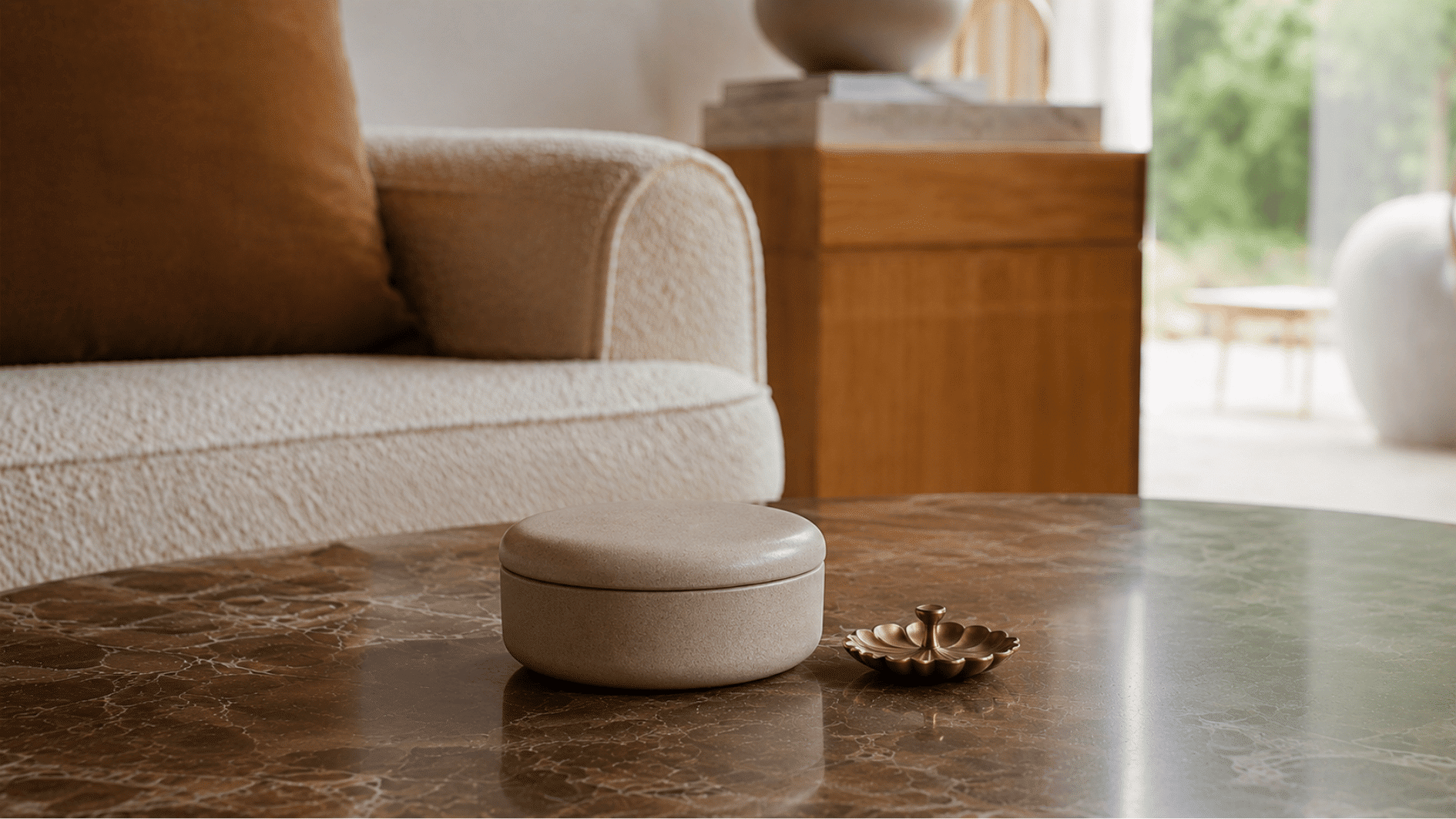 Ceramic keepsake box and small gold brass dish styled on a dark marble coffee table