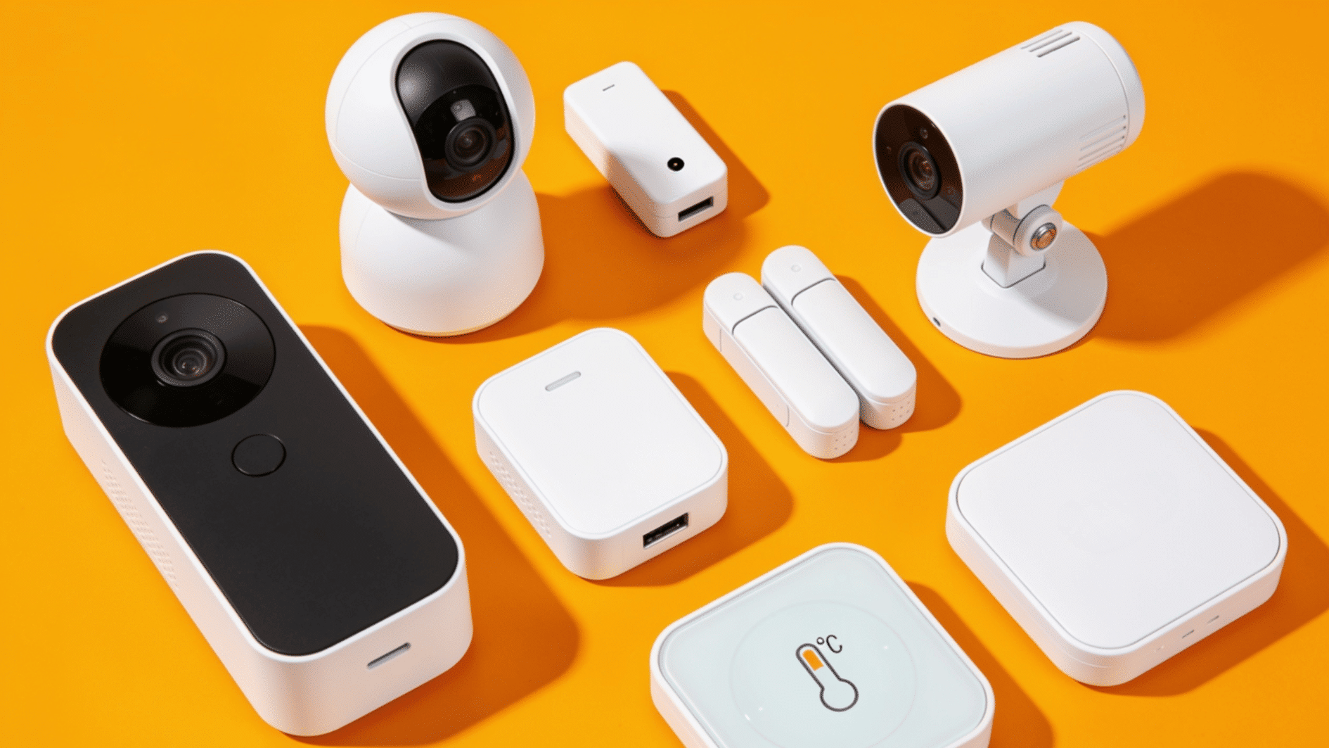 collection of smart home security devices including cameras sensors hub and temperature monitor on yellow background