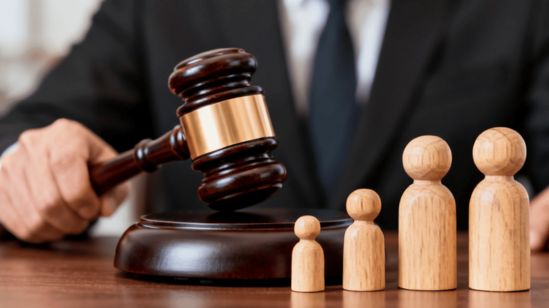 judge's gavel beside wooden family figures symbolizing family law child custody and legal proceedings
