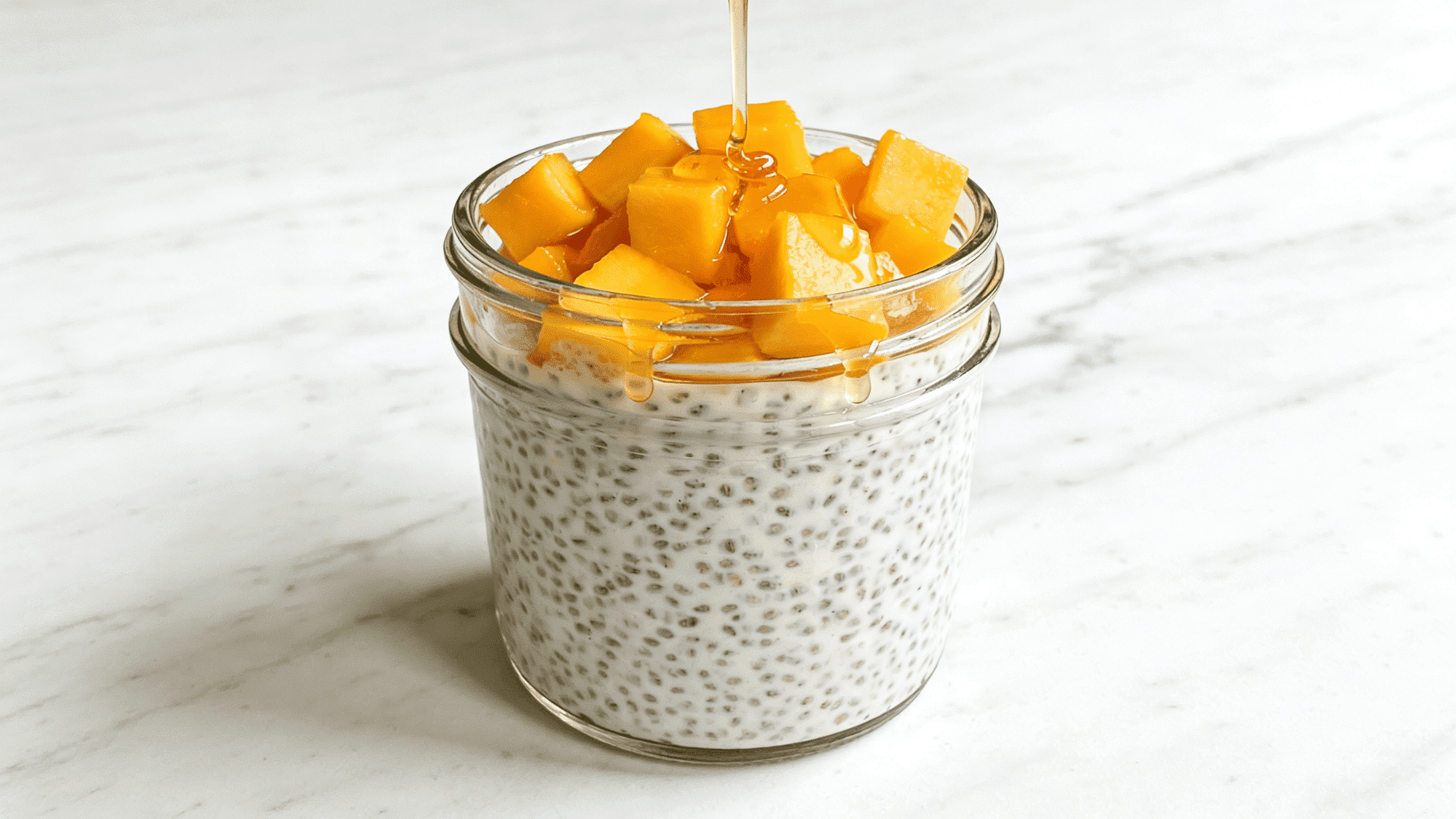 mango chia pudding in glass jar with diced fresh mango and honey drizzle, healthy meal ideas for kids (1)