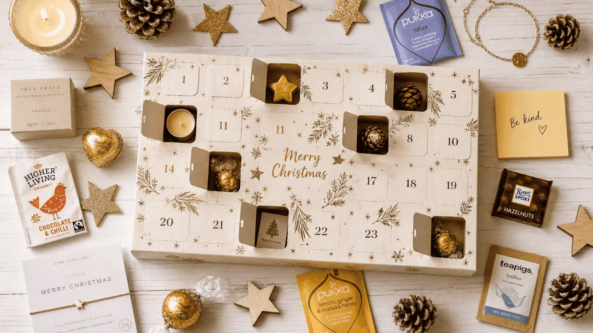 open advent calendar box with numbered doors surrounded by festive fillers on white wood
