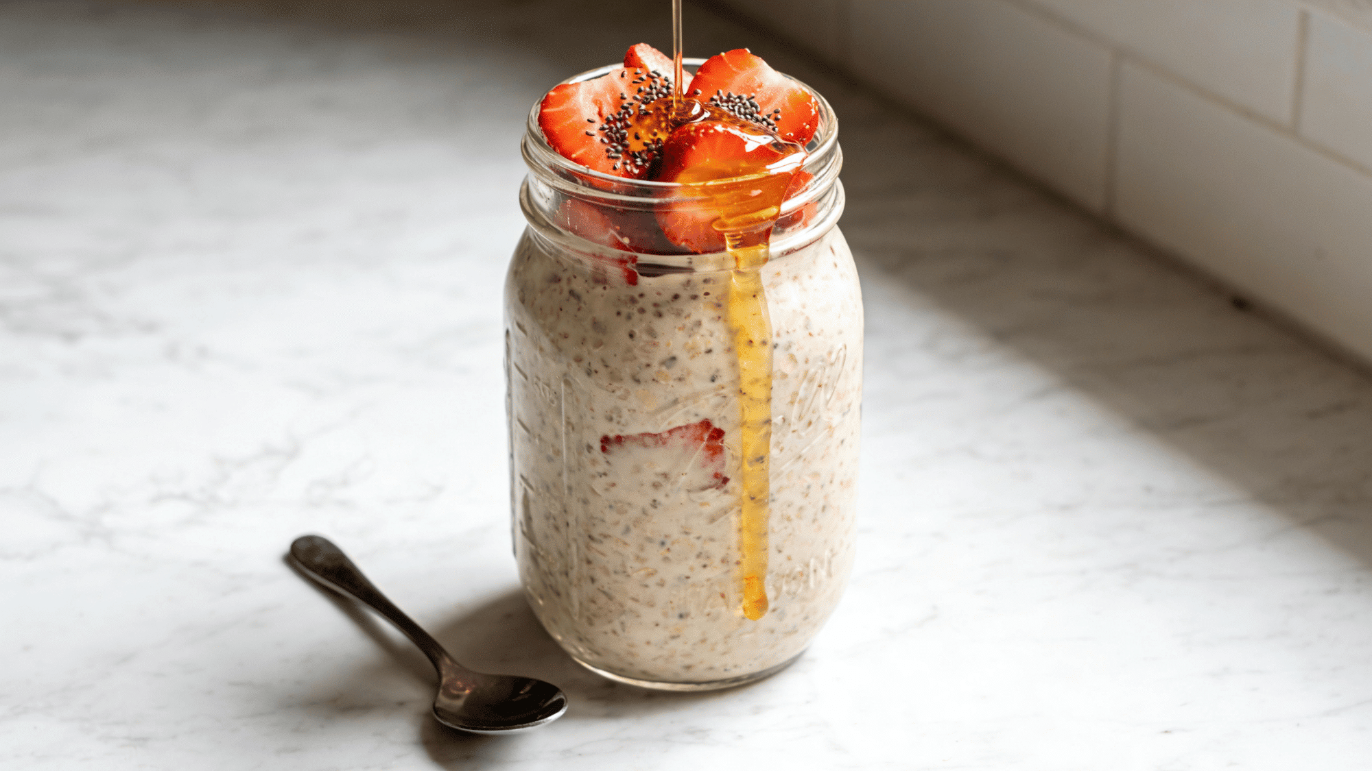 _overnight oats in mason jar topped with strawberries and honey drizzle, healthy breakfast meal ideas for kids