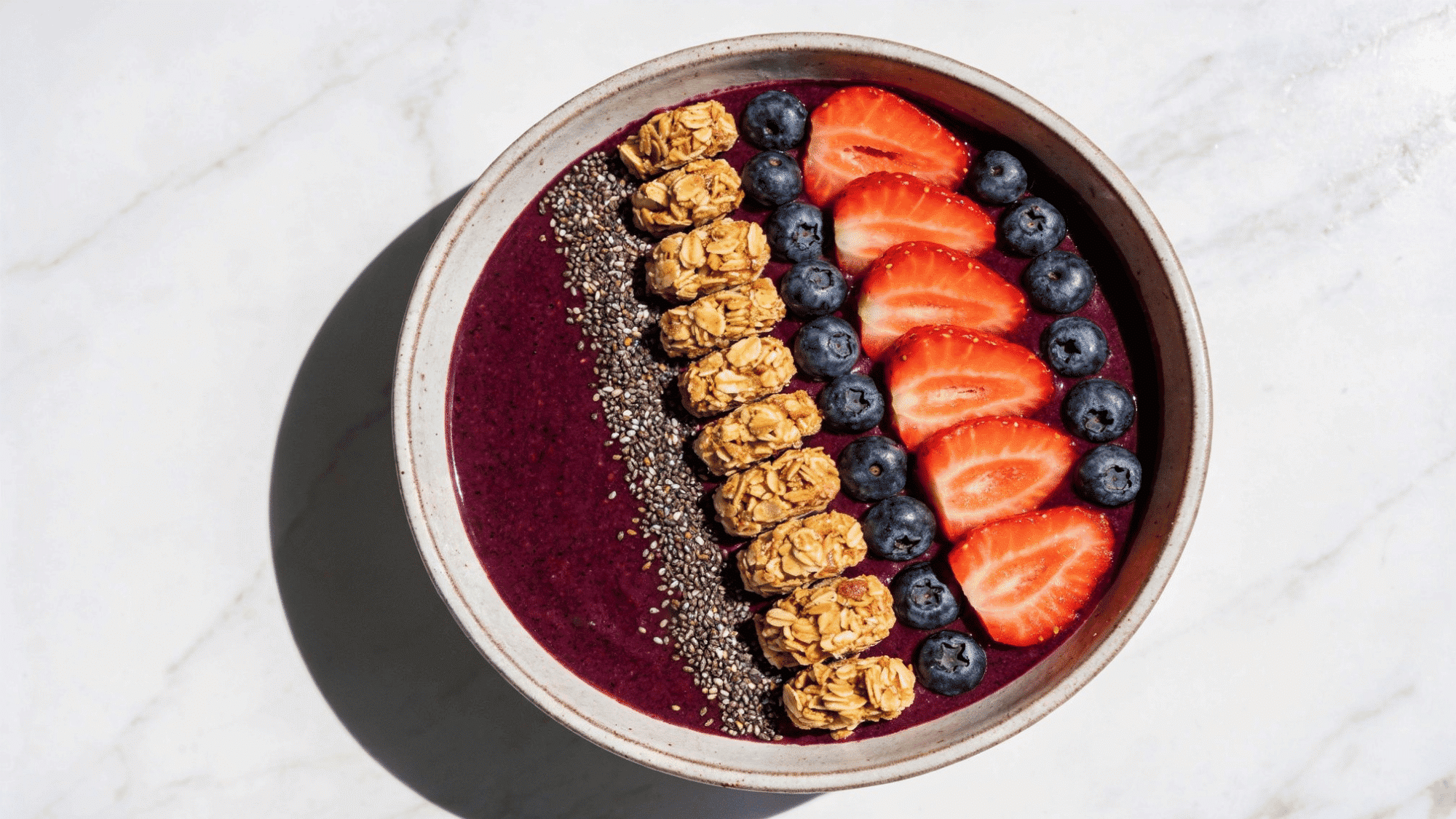 smoothie bowl with berry base topped with granola strawberries and blueberries, healthy meal ideas for kids