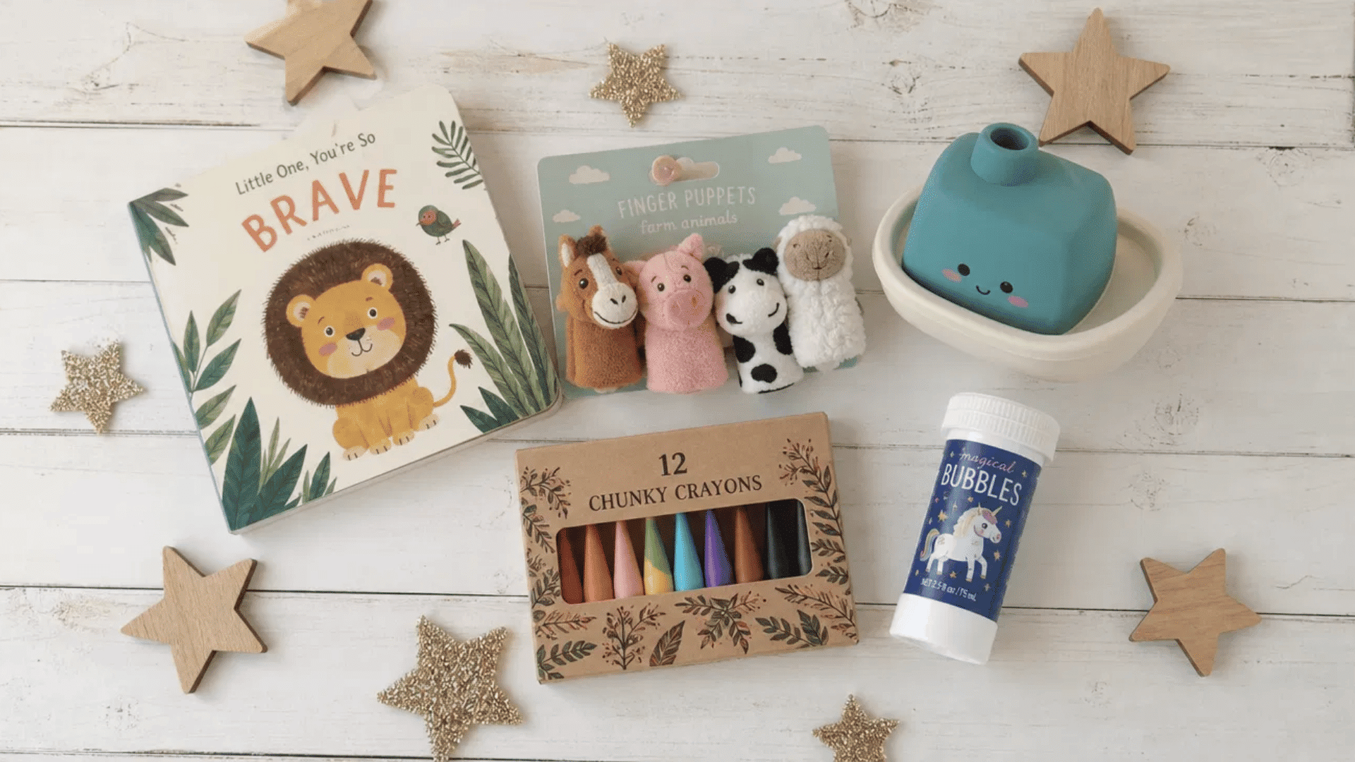 toddler advent calendar fillers with finger puppets, board book, crayons, and bubbles on white wood