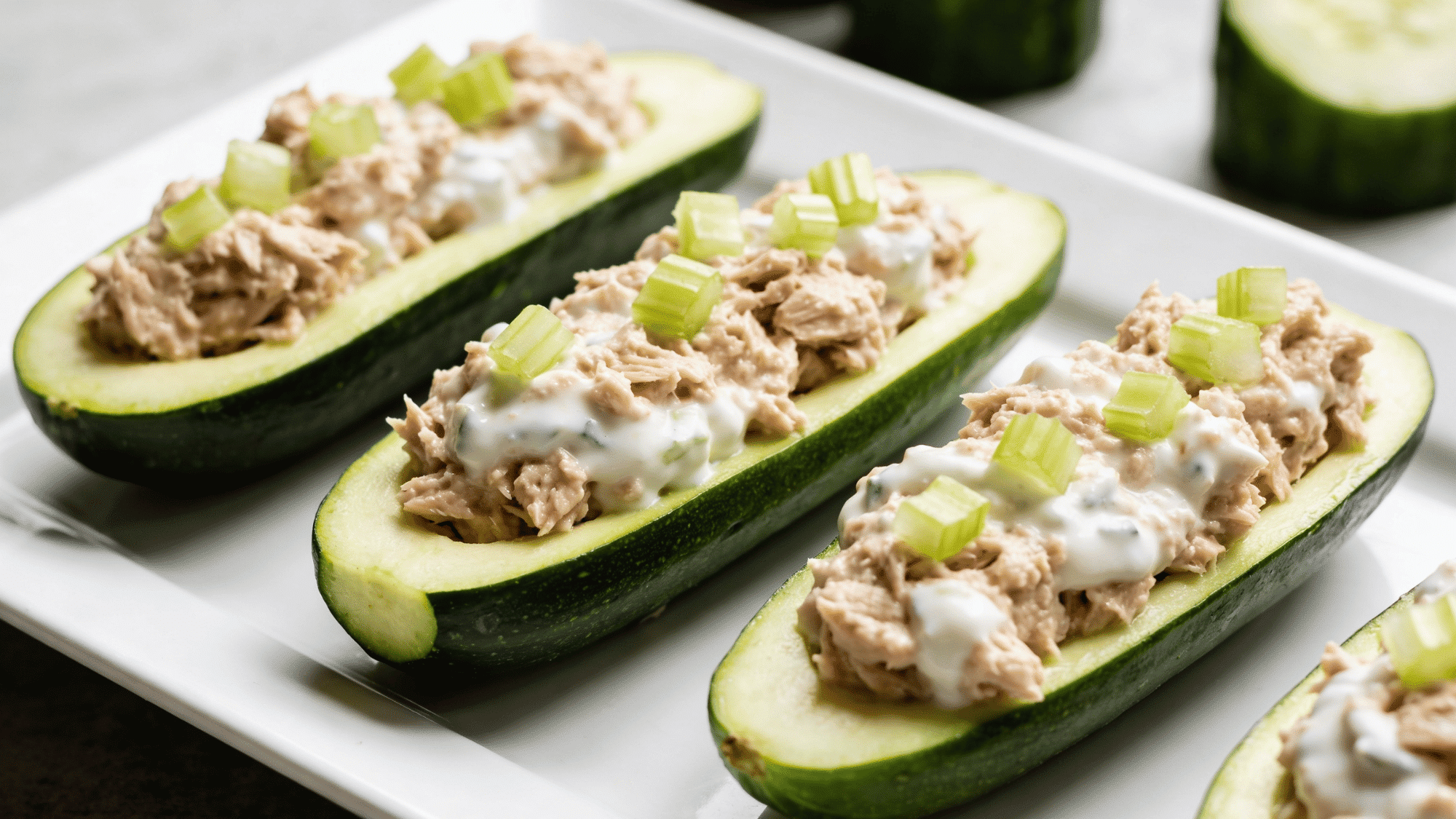 tuna cucumber boats filled with creamy tuna and yogurt mix on white plate, healthy quick meal ideas for kids