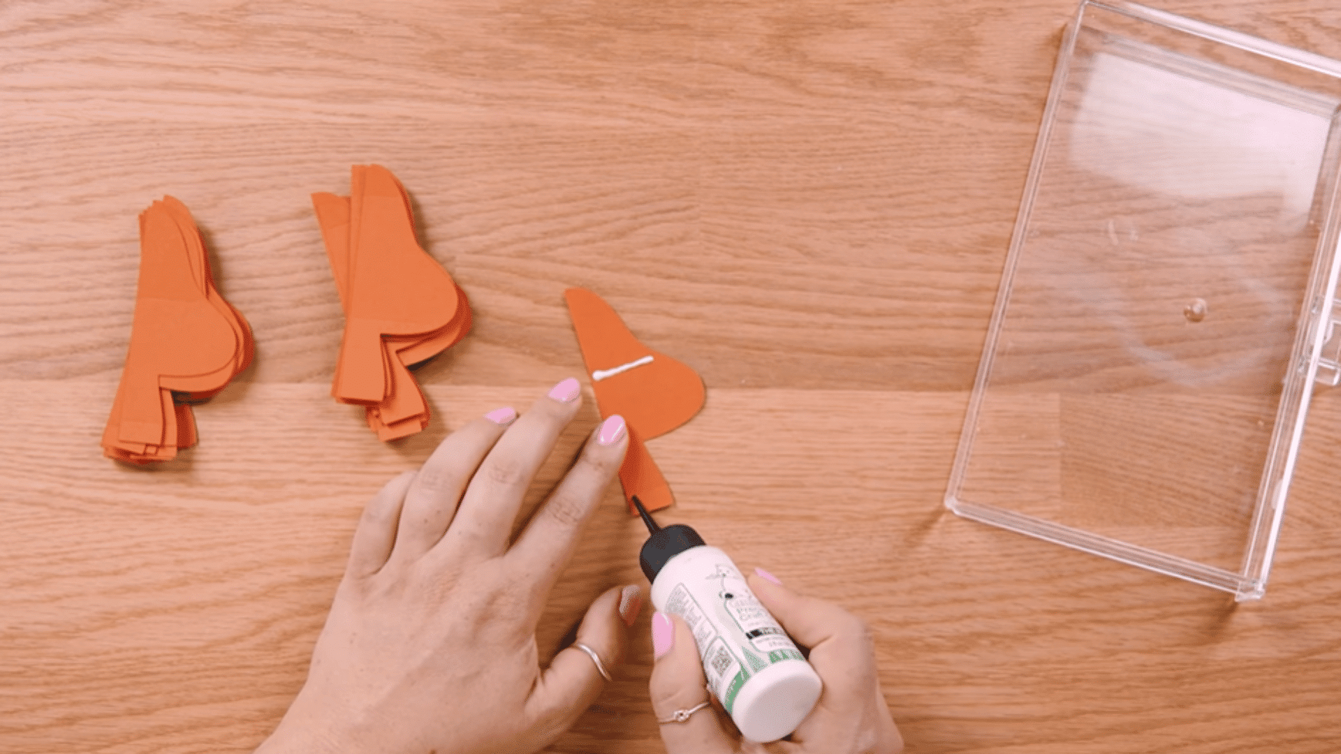 applying a thin line of glue along score lines on a cardstock mushroom piece on a flat surface